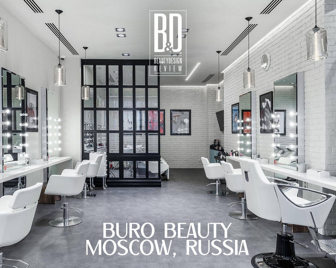 Светлый интерьер салона красоты с кирпичными стенами и белой мебелью