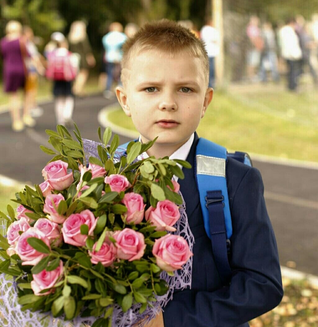 Внуки пошли в школу. Ребенок несет цветы.