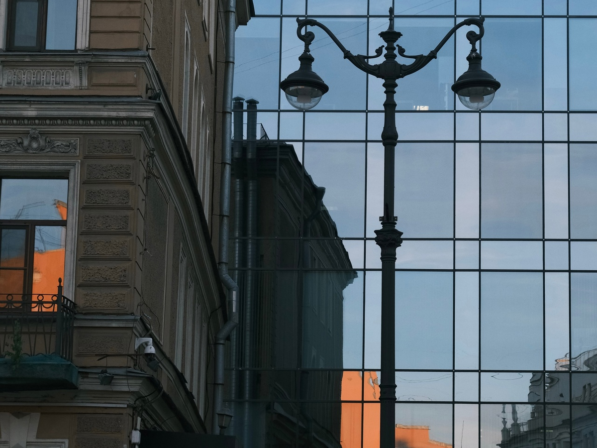 Холодное стекло современной минималистичной архитектуры служит выгодным фоном для старинной застройки и благодаря большим отражающим поверхностям создает новые объемы