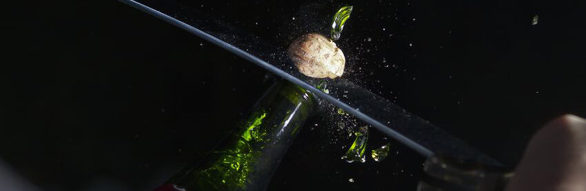 Изначально сабраж (от французского слова sabrе — сабля) это способ открыть бутылку игристого вина саблей, лихо сбив горловину бутылки. Позже вместо сабли иногда стали использовать специальный нож или даже вообще не режущий предмет. По-русски сабраж еще называют «открывание бутылки по-гусарски». Традиция сабража жива и по сей день — уж очень эффектно выглядит. Когда же уместно проводить сабраж и как делать его правильно?