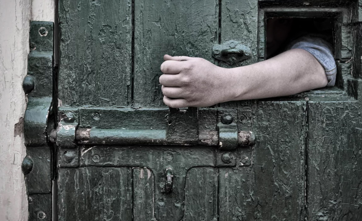 Человек стучит в дверь. Закрытая дверь. Запертая дверь. Тюремная дверь. Дверь в тюрьме.