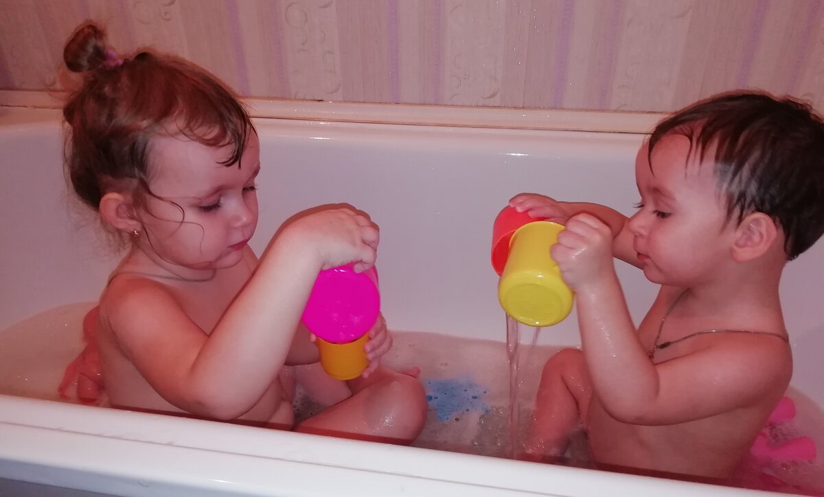 Когда Глебик был ещё кроха, естественно для него, была отдельная ванночка, кипяченая водичка с отварами  то ромашки, то череды.Горкой мы не пользовались, хотя нам подарили аж две штуки. Зато специальный круг для купания выручал пару месяцев. Уж незнаю, с его ли помощью, сынок начал переворачиваться на животик рано, и рано стал присаживаться на попу. Ведь плавание, задействует все мышцы в теле, снимает тонус.                              
 Когда он подрос, стал уверенно сидеть, я купила ему стульчик для купания. Как по мне, то это бесполезная вещица. Во-первых, присоски еле схватывались с покрытием ванны, во вторых, натереть ребенка мочалкой, невозможно. В третьих-разноцветные колесики, что спереди, сделаные наверное для игры, надоели за первое купание. Ну и самое главное, что вытащить ребёнка, с этого сидения, не причинив ему неудобства, практически невозможно.Решила отдать знакомой. Она тоже оказалась не в восторге, и кому то его сбагрила. Дочка с рождения обожает купаться как и многие дети. То и дело просит набрать ей ванну,собирает кучу формочек, стаканчиков, зверушек и на 40 минут погружается в игру. Чтобы "убить двух зайцев", я стала купать их вместе.                                                                            
Лерочка рассказыает ему про игрушки. К примеру, что уточка, это птичка, что цвет её желтый, и показывает ему как она крякает. Естественно, оставлять их одних даже на минуту нельзя. Возможно в игре, дочь сможет его толкнуть, и тогда последствия могут быть серьезные. Вообще, Лера моя спасительница. Помогает мне в уходе за младшим. Казалось бы, такие мелочи, как принести подгузник, снять с него носочки, но на самом деле, это огромная помощь.В свои 3 с небольшим годика, она охотно рассматривает с ним книги,и находит ему занятие, пока я занята делами. Благодаря ее примеру, младший умеет чистить зубки, сплевывает, и полоскает ротик. 