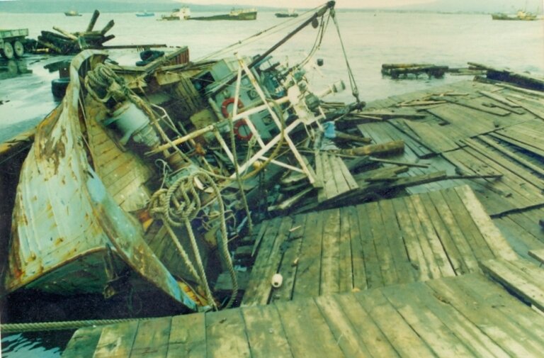 Рыболовецкое судно, выброшенное цунами на пирс Южно-Курильска. Октябрь 1994 г. Из фондов Южно-Курильского краеведческого музея. Автор фото: Геннадий Березюк.