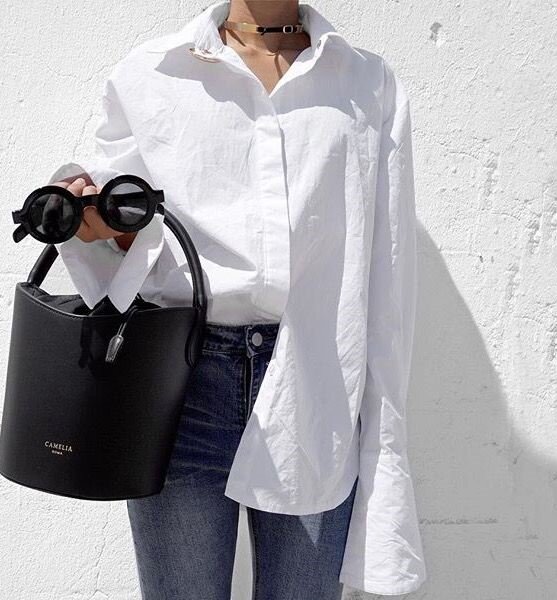 Ставшее уже классическим сочетание белой рубашки с джинсами лучше разбавить интересными аксессуарами - стильные очки и сумочка придадут вашему образу нужное настроение.