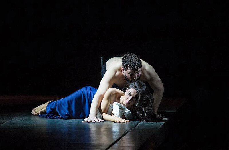 Постановочный тандем режиссера Екатерины Одеговой и сценографа Этели Иошпы сумел расслышать эту аскетичность и лапидарность и ничем ее не нарушить. Иошпа прямо говорит, что «сам материал меня так сильно сразил, что хотелось быть в нем практически незаметной». Оттого — ​тотально темная сцена, атмосфера сумрака и тумана лишь изредка нарушается игрой струящегося света Тимофея Ермолина. Мрачные геометрические фигуры — ​огромные кубы, олицетворяющие жесткий мужской мир этрусков, противопоставлены зыбкой водной ряби, мерцающей на заднике и говорящей о нежной женственности. Удивительны костюмы, в которых переплетены самые разные мотивы — ​эпохи и стили, брутальность и чистота, фарс и трагизм.