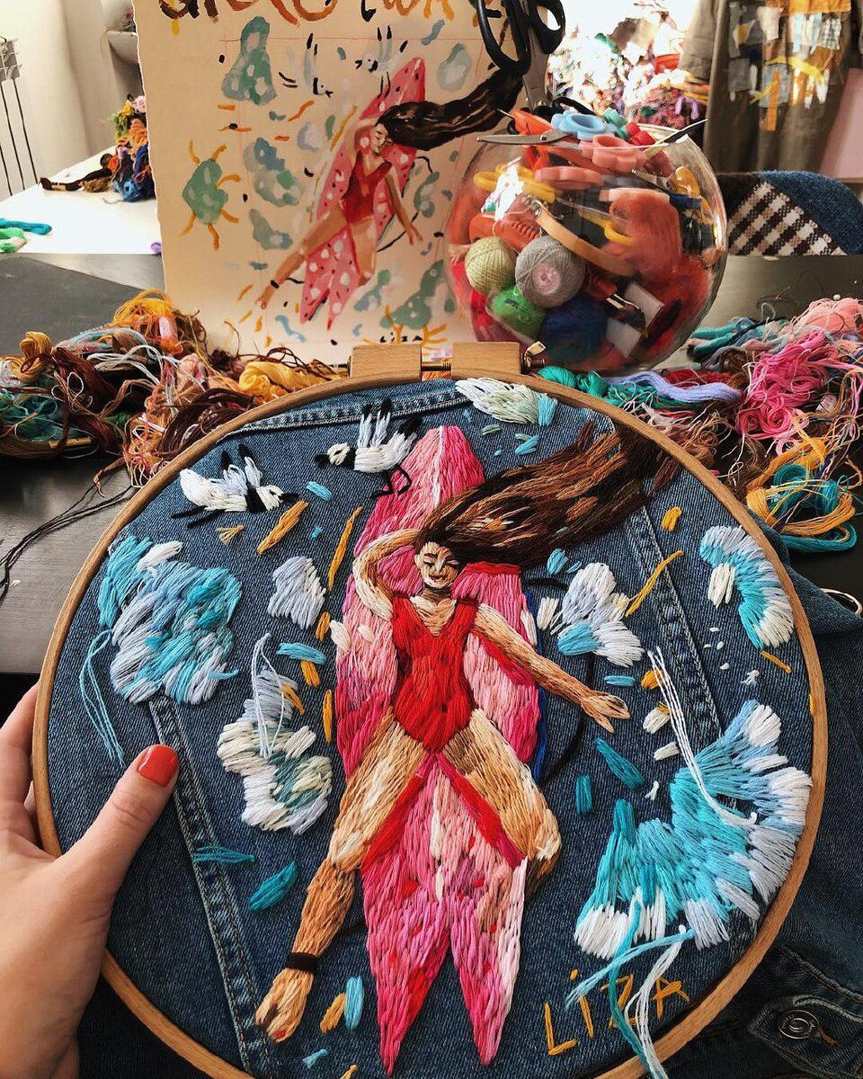 Вышивка на джинсовой куртке. На заднем плане виден эскиз изображения.