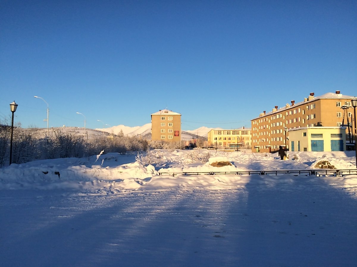 Недавно у моей коллеги на работе муж уехал на Чукотку по работе на  стажировку. Учиться он там ремонтировать вертолёты. Конечно далеко, но и з/п обещали под 200 000. Подумали они семьей и решили: деньги хорошие, надо ехать. А по приезду он понял, почему такие зарплаты.  Уехал он в город Белибино, город  не большой, население около 5 000 человек. Город окружен деревьями, словно находишься не на Чукотке, а в Якутии. Лиственницы в прилегающей к городу тайге контрастируют с пейзажами остальной территории Чукотки, которая преимущественно состоит из тундры и лысых горных хребтов. Добраться до Билибина с материка можно только по воздуху (если не считать автозимник Магадан – Зырянка – Билибино длиной 2500 км) из Магадана или Анадыря. Полёт Магадан – Кепервеем (аэродром в 40 километрах от города) займёт три часа.