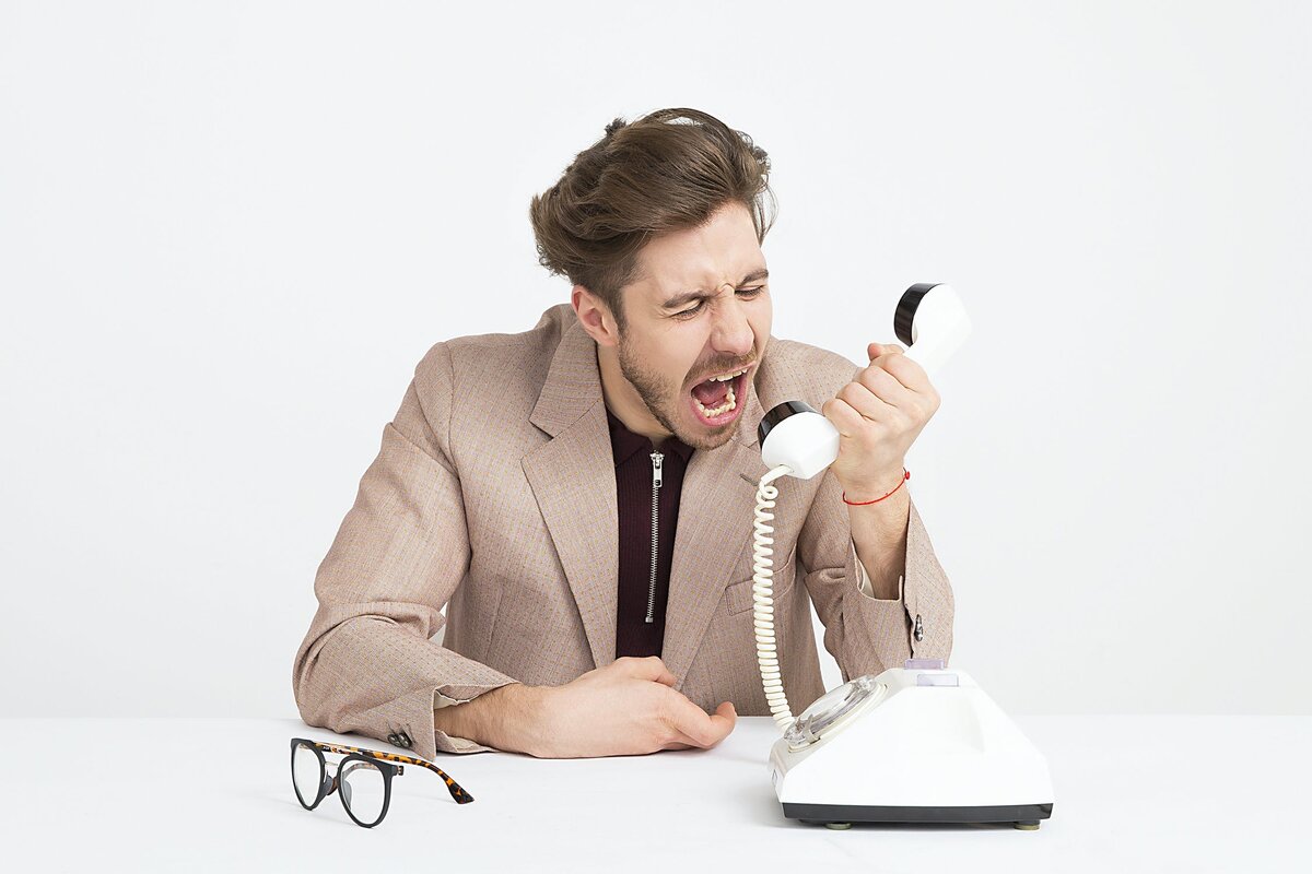 https://www.pexels.com/photo/man-wearing-brown-suit-jacket-mocking-on-white-telephone-1587014/