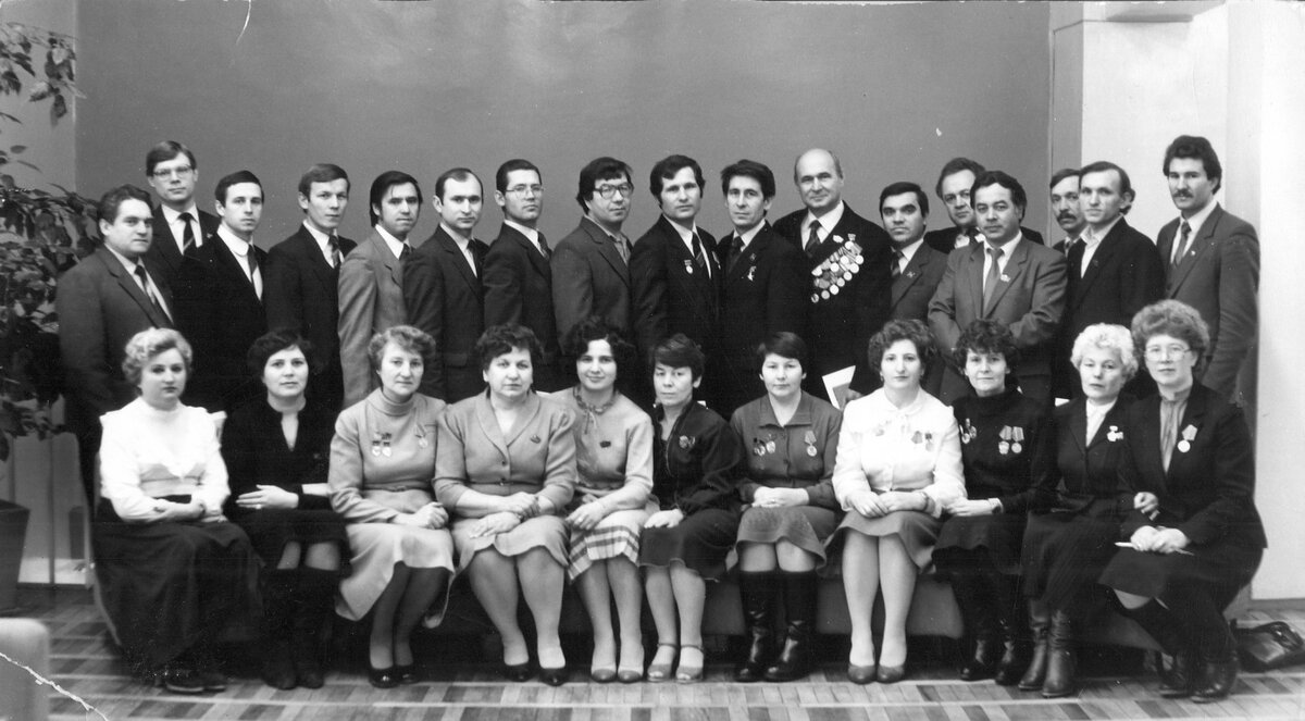 Сидят слева направо: 1. Руденская Галина Павловна - заведующая сектором учета парткома ПРЗ. 2. … 3. Клюкина Клавдия … - мастер цех сборки сварки шасси. 4. Иовлева Валентина Александровна - секретарь парткома ПРЗ. 5. Мочалова Таиса Дмитриевна - секретарь партбюро цеха станкостроения. 6. Александрова Раиса Яковлевна - председатель цехового комитета прессового цеха. 7. Мирзаянова Альфия - председатель цехового комитета цеха окраски №2. 8. … 9. Соколова Зоя Валентиновна - член парткома ПРЗ. 10. … 11. Аксенова Тамара - председатель цехового комитета цеха окраски №1.  Стоят слева направо: 1. Скоробогатов Владимир Николаевич  - начальник участка энергосилового цеха. 2. Мартынюк Владимир Петрович - заместитель секретаря парткома ПРЗ. 3. Савельев Александр Борисович - секретарь парткома ПРЗ. 4. … 5. Хуснутдинов Фарид Абдуллович - заместитель председателя профкома ПРЗ. 6. Ахметзянов Рашид Сабирзянович - председатель профкома ПРЗ. 7. … 8. … 9. Малышев Василий Алексеевич - наладчик цеха ремонта штамповой оснастки, лауреат Государственной премии СССР (1984).  10. Иманов Зуфар Минтемирович  - шлифовщик цеха изготовления штампов, Герой Социалистического труда. 11. Камалов Ильбатыр Латыпович  - цех изготовления штампов, участник Великой Отечественной войны. 12. Нуретдинов Гумер Хасанзанович - председатель профкома КАМАЗа. 13. Гритчин Владимир … - слесарь ЦЛИТ, диктор ведущий первомайских и ноябрьских демонстраций в городе Набережные Челны, различных мероприятий на КАМАЗе и в городе. 14. Морозов Юрий Афанасьевич - заместитель директора завода по кадрам и социальному развитию. 15. … 16. … 17. Емельянов Виталий …- комитет ВЛКСМ ПРЗ.