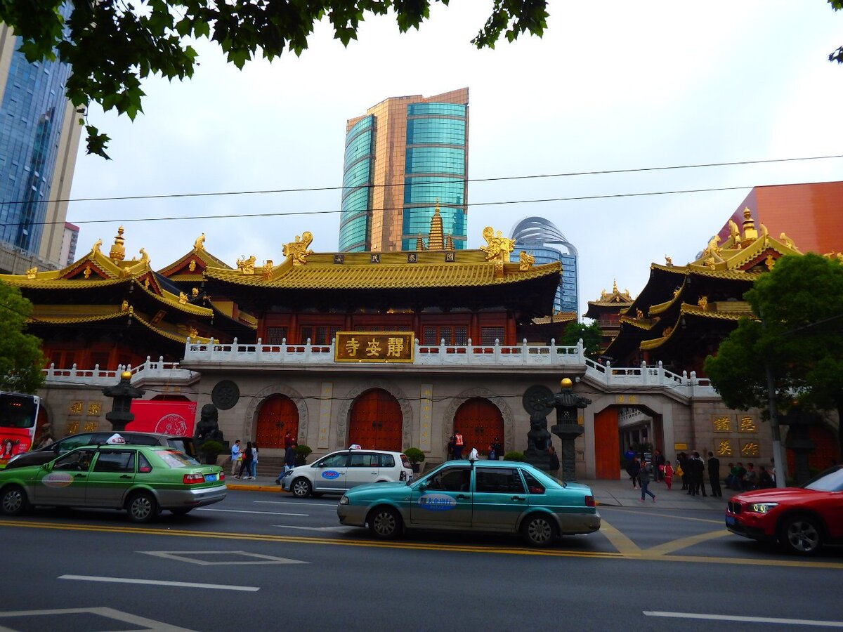Как добраться
К храму выходит одноименное метро Jing An Temple. Выход 1, налево до перекрестка и направо. Тут и ворота в храм.

Вид на ворота с другой стороны дороги.

