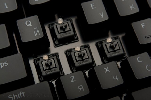Немного информации. Cherry MX Black  – переключатели равномерного нажатия, направлены на борьбу против  фиктивных нажатий, так как для достижения точки срабатывания приходится  приложить больше усилий, если сравнивать с другими переключателями серии  Cherry MX. Момент срабатывания и опускания расположена на  одном и том же уровне, что позволяет осуществлять многократные нажатия  за короткий отрезок времени. Переключатели характеризуются равномерным  ходом. Глубина хода составляет 2 мм до срабатывания, и 4 мм до упора.  Стоит заметить то, что Cherry MX Black не имеет отдачи, и нет  четкого звукового щелчка, то есть при срабатывании пружины абсолютно не  слышен характерный «кликающий» звук. Благодаря таким особенностям, эти  переключатели отлично подходят для игр и пользуются спросом у  поклонников игр. Все типы переключателей производства компании Cherry  характеризуются внушительным ресурсом нажатий равным 50 млн., в то  время как клавиатуры мембранного типа имеют гораздо меньший срок службы.  Фото: CC by 3.0