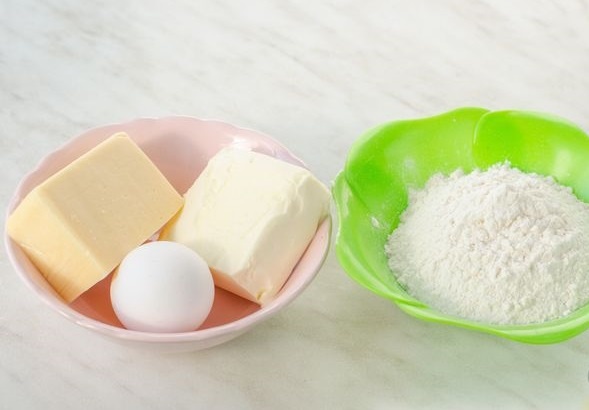  Подготавливаем продукты для приготовления сырных крекеров. В процессе готовки нам понадобится пергаментная бумага, пищевая пленка и соломинка для напитков.
Сливочное масло должно быть из холодильника.