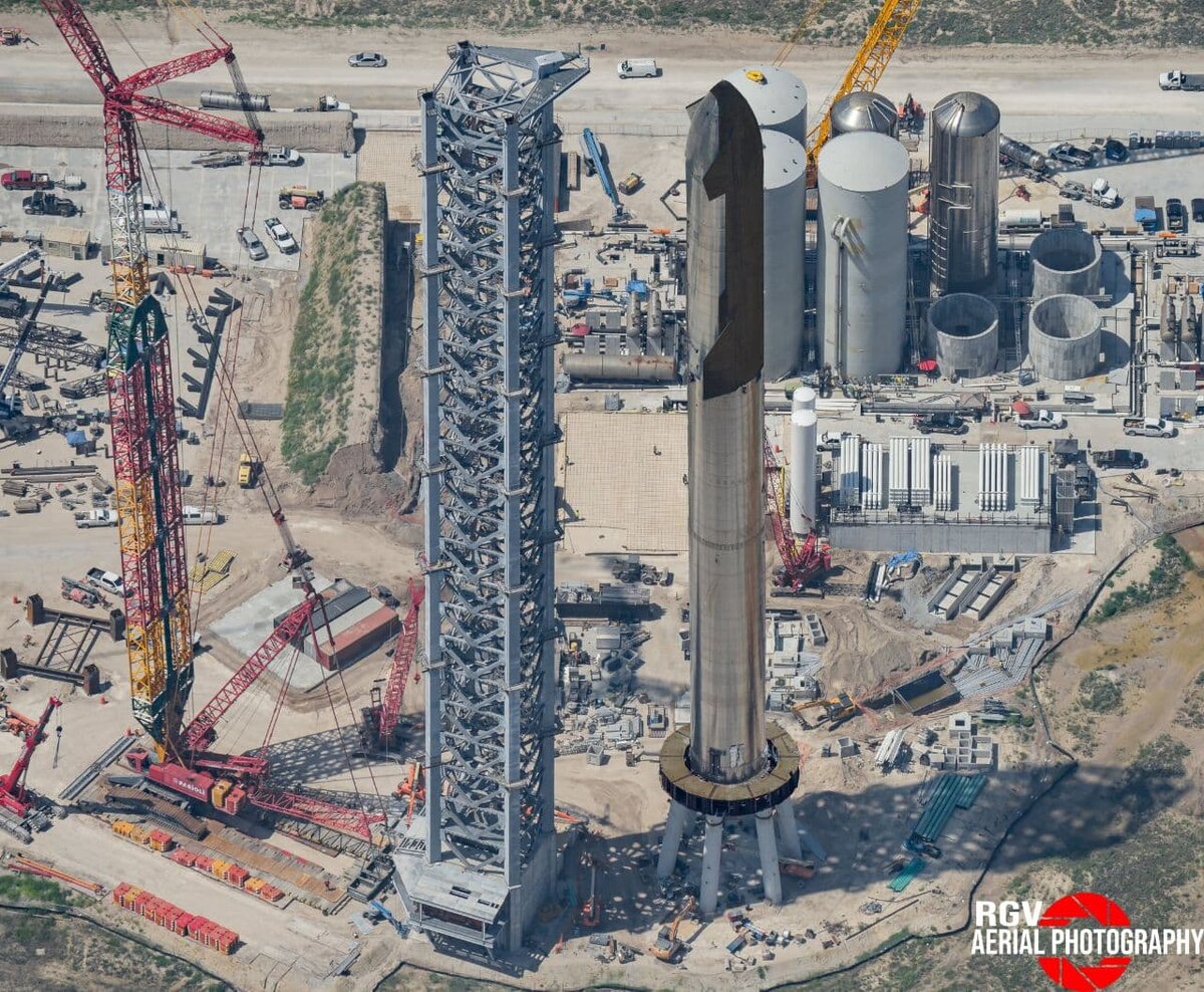 Как будет выглядеть система Starship в сборе  
Сборка корабля и ускорителя для первого орбитального полёта идёт полным ходом, башня обслуживания и инфраструктура тоже не отстают. Но единого мнения о том, когда всё будет готово, пока нет.