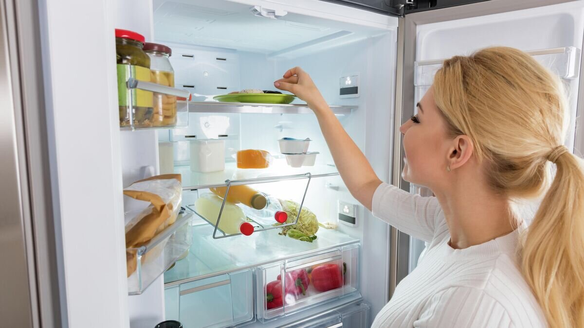   Девушка достает продукты из холодильника© Depositphotos / AndreyPopov