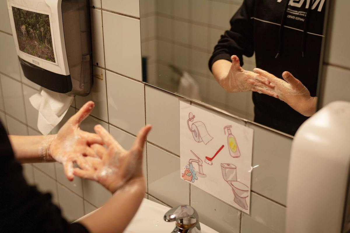 A student practices safe hand-washing at the Korshoejskolen Public school.