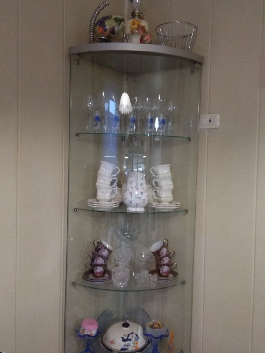 Стеклянная витрина в противоположном углу столовой.