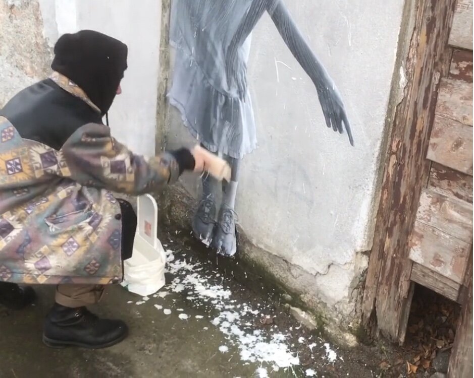 Фернандо клеит свой плакат к стене