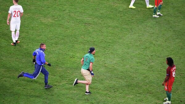    Выбежавший на поле болельщик в матче 1/4 финала чемпионата Европы по футболу между сборными Польши и Португалии© REUTERS / ERIC GAILLARD