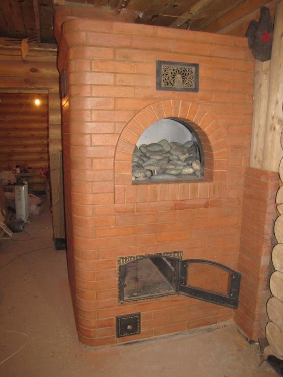 Кирпичная печь будет дольше держать тепло. Кроме этого, важным плюсом является ее пожаробезопасность. Но кладка кирпичной печи – это технологически сложный и трудоемкий процесс. Поэтому устройство кирпичной печи для бани придется, скорее всего, доверить профессионалам, которые хорошо знают все тонкости технологии, конструирования и монтажа печей. Материал для такой печи также существенно увеличит ваши финансовые потери.Фото: Кирпичная печь 
