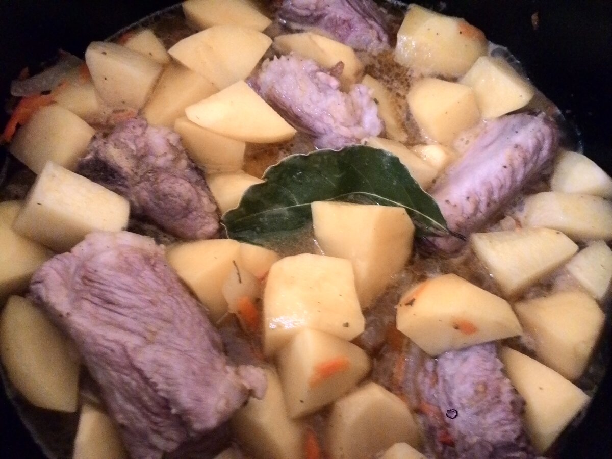 картошка с копчеными ребрышками тушеная. свинина с картофелем. жаркое со свиными ребрышками. картошка тушеная с свиными косточками. тушеная картошка с свиными ребрышками в кастрюле.