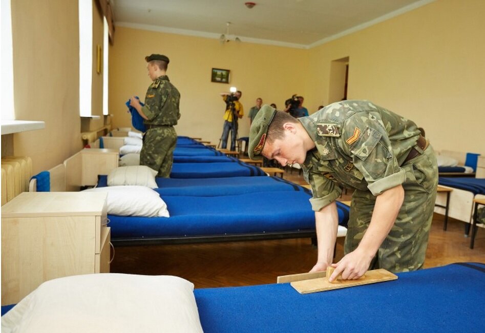 В руках у товарища солдата так называемые «отбивы», использующиеся  для создания у кровати армейского эстетичного вида.