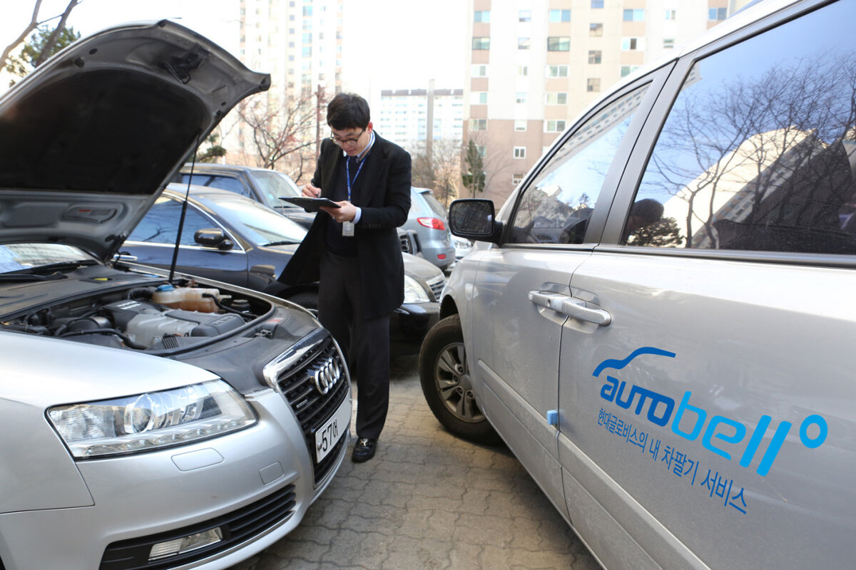 Сотрудник Hyundai Glovis осматривает подержанный автомобиль (Hyundai Glovis)
