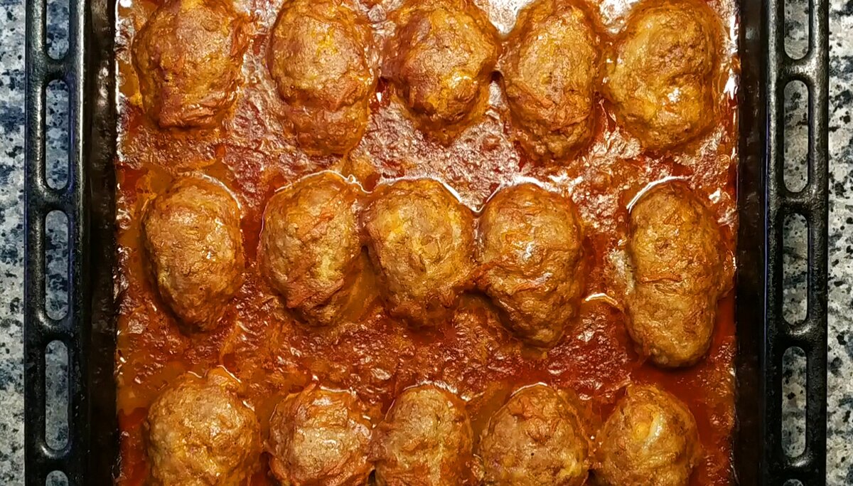 Домашние котлеты из фарша с томатной подливкой получаются очень сочными и невероятно вкусными. Прекрасно сочетаются с любым гарниром. 
Ингредиенты:
Для котлет (17 шт.):
фарш (говядина+индейка) - 1000 гр
батон (мякиш) - 250 гр.
молоко - 200 мл.
чеснок - 5 зуб.
лук - 200 гр.
соль, черный перец
мука для обваливания
масло растит. 10 мл. для смазки противня
Для подливки:
мука - 50 гр.
вода - 1 л.
масло растит. - 60 мл.
лук - 150 гр. (2 ср.шт.)
морковь - 100 гр. (1 шт.)
томатная паста - 2 ст.л.
Специи: душистый перец молотый, черный перец молотый, лавровый лист, соль и сахар по вкусу.

1. Приготовить подливку. Муку обжарить на сухой небольшой сковороде до кремового цвета. Остудить и влить теплую воду (250 мл.) из общего количества. Прогреть и перемешать так, чтобы не оставалось комочков, затем отложить в сторону.
2. В отдельной большой сковороде на растительном масле обжарить лук до прозрачности, нарезанный небольшими кубиками. Затем добавить морковь, натертую на крупной терке, обжаривать на среднем огне 3-5 минут.
3. Далее добавить томатную пасту, перемешать и обжаривать 1-2 минуты. Затем влить остатки воды (750 мл.), добавить все специи по вкусы, перемешать и варить на небольшом огне 3-5 минут.
4. В сковороду с луком и морковью влить мучную смесь, перемешать, выключить плиту. 
5. Приготовить фарш с луком, чесноком, черным перцем и солью. Батон размочить в молоке, отжать и добавить в фарш. Тщательно вымесить. Сформировать котлеты продолговатой формы, обвалять их в муке.
6. Выложить котлеты на смазанный противень, сверху залить приготовленным соусом.
7. Запекать в разогретой до 190 градусов духовке 50-60 минут.
Любой гарнир прекрасно сочетается.