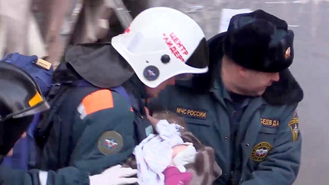 Сотрудники МЧС РФ во время извлечения живого 10-месячного ребенка из-под завалов в результате взрыва газа в жилом доме в Магнитогорске. Фото: ТАСС/пресс-служба МЧС РФ/снимок с видео