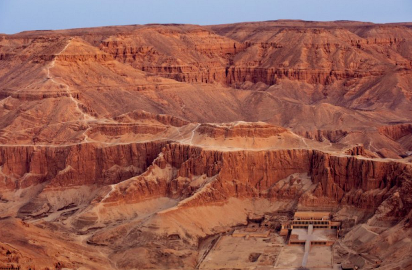 Поминальный храм Хатшепсут обрамляют отвесные холмы Западной пустыни. За самым высоким хребтом начинается гигантская расщелина. Это Долина царей – кладбище фараонов, где расположен вход в гробницу Хатшепсут. Ее отец, судя по всему, первым из фараонов обустроил себе последний приют в долине. Заложенная им традиция просуществовала более четырех веков. Фото: Кеннет Гаррет