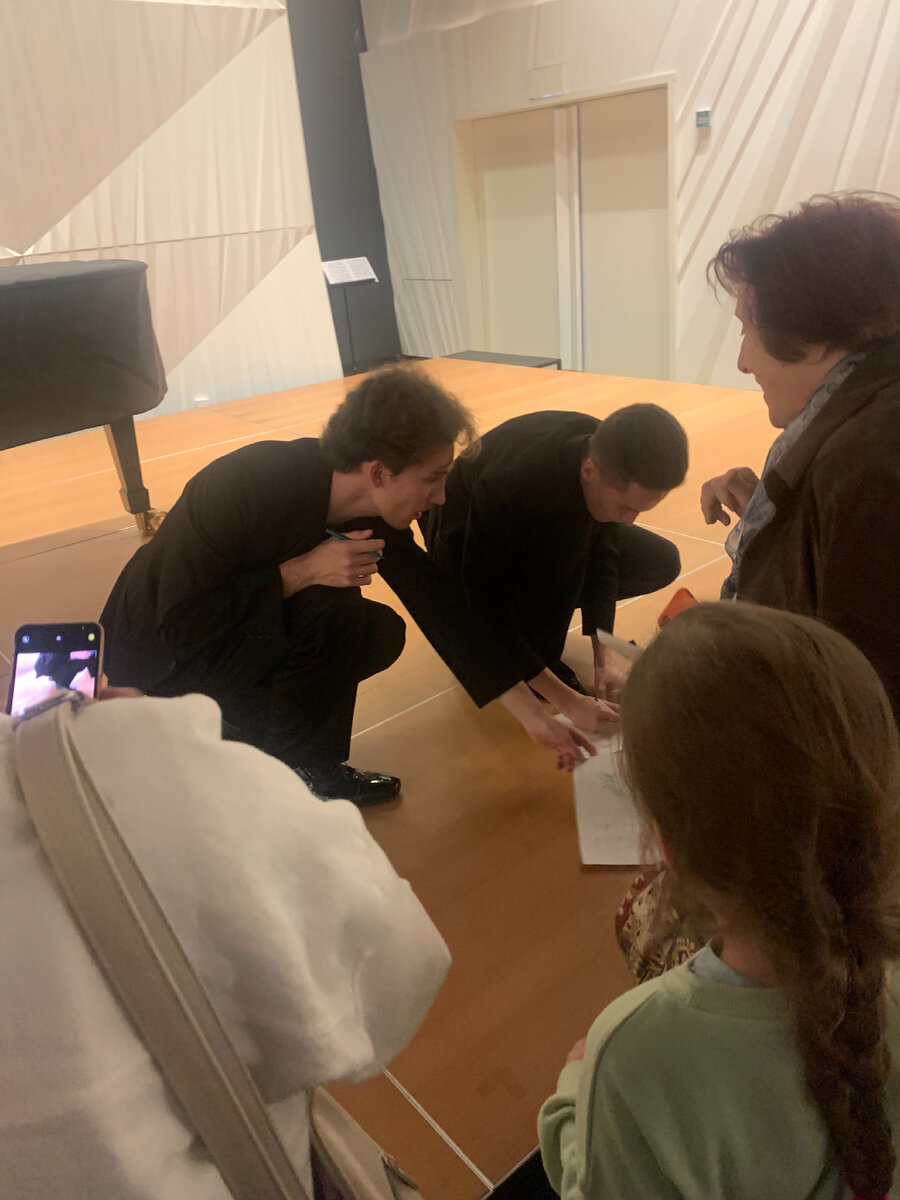 Валентин (слева) и Михаил (справа) дают автографы детям на программках и рисунках.