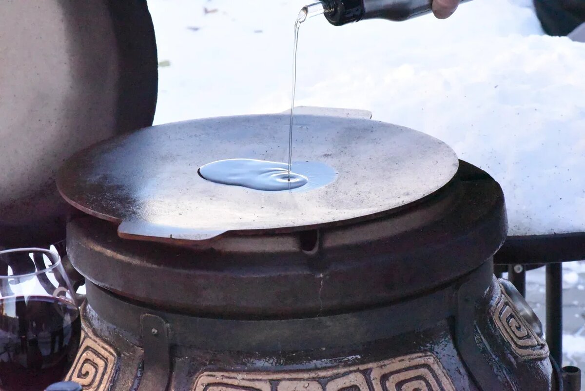 Тандыр растопили, значит, на его горловину нужно поставить чугунный садж и хорошо прогреть — тогда овощи не прилипнут к его поверхности во время жарки. Мы готовили на плоском садже, а вы можете взять поглубже. Налейте на него немного масла, только не переборщите, и обжарьте лук до золотистого цвета.