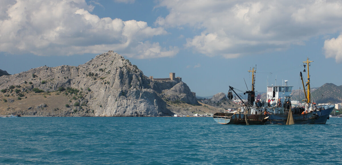 Башни и стены генуэзской крепости на рифовой скале.