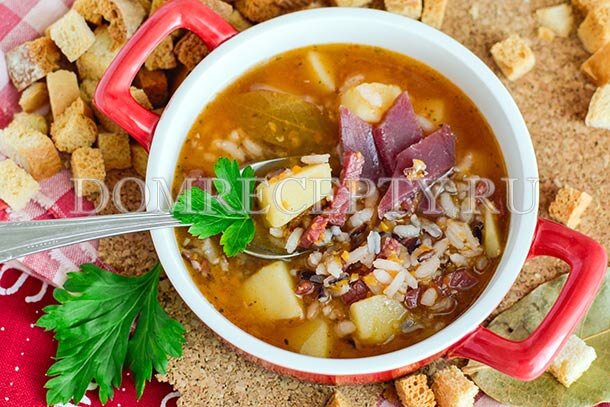 Несмотря на затейливое название, этот суп невероятно простой в приготовлении, а поэтому идеально подойдет для рабочего буднего дня. На приготовление супа с бастурмой у вас уйдет совсем немного времени, а сама технология очень проста – настолько проста, что вам даже не придется делать, казалось бы, обязательную поджарку из овощей. Так получается потому, что вкус супа будет достаточно насыщенным, а поэтому в поджарке отпадает надобность – важно подчеркнуть вкус главных ингредиентов. Бастурма придаст этого первому блюду пикантность и легкий аромат вяленого мяса, а два вида риса сделают блюдо сытным и питательным, а также создадут необычную текстуру. Так, первый сорт риса, который используется для приготовления супа – это дикий рис, который легко узнать по черному цвету. Он долго варится и остается целыми зернышками, лишь слегка приоткрываясь. Второй же сорт риса обеспечит супу густоту и наваристость, потому что в нем много крахмала – это рис сорта Камолино. Вы можете использовать любой другой круглый сорт риса, который у вас найдется.
Овощи, которые входят в состав супа, будут дополнять вкус и обогащать его: их лучше всего измельчить в блендере в однородную кашицу – так они станут как бы частью бульона, особо не выделяясь.
ИНГРЕДИЕНТЫ
200 граммов бастурмы (или другого вяленого мяса)
2 горсти круглого риса сорта Камолино (или другого сорта)
1 горсть дикого риса
3 картофелины
1 морковь
1 луковица
2 зубчика чеснока
20 граммов сливочного масла
2 лавровых листа
1 ч. ложка паприки
1 ч. ложка томатной пасты
соль, перец по вкусу