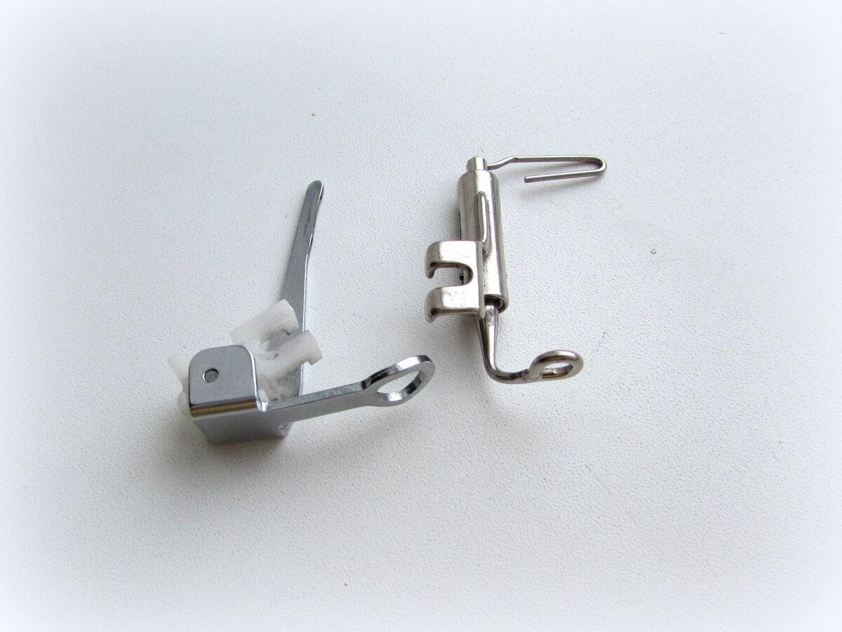 Первая лапка из универсального набора лапок, вторая очень древняя, шла в комплекте к моей старой подольской швейной машинке, называлась она "лапка для штопки". На фото не видно, но внутри у неё пружинка.