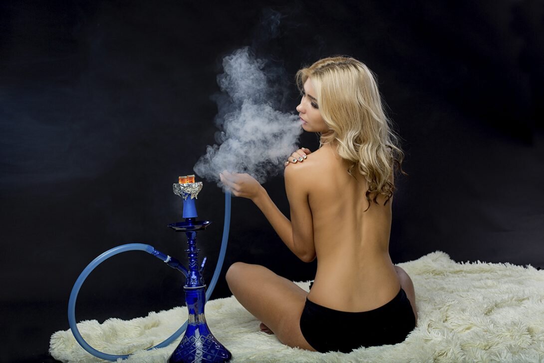 Этикет курения кальяна: 
Даже самые заядлые курильщики могут удивиться, узнав, что существует настоящий кальянный этикет, которого нужно придерживаться. Оказывается, это один из наиболее важных аспектов использования кальяна, и тем, кто только начинает увлекаться данным видом курения, обязательно стоит о нем знать.

В восточных и арабских культурах кальяну отведена особая ниша. Культура проведения сеанса сравнима с чайной церемонией: множество деталей и условностей, которые делают сеанс неповторимым.

Конечно, в современном мире все иначе и традиции меняются, в соответствии со временем. Но некоторые правила остаются неизменными, и о них непременно стоит знать тем, кто увлекся дымным.

Нормы кальянного этикета: как курить кальян правильно

Существует несколько основных правил, о которых обязательно стоит знать всем заядлым курильщикам, а также тем, кто только начинает курить кальян. Эти обычаи не только объясняют, как правильно нужно курить кальянные смеси, но также рассказывают, что при курении делать категорически нельзя:

1) Процесс подготовки самого прибора должен проходить в спокойном темпе, и ни в коем случае не стоит проявлять спешку

Кальян — это особое настроение, это время, которое стоит уделить приготовлению прибора, забивке, раскурке и эти процессы не терпят спешки. Поэтому решив провести сеанс убедитесь что у вас есть на это время. Приготовление занимает до 15-20 минут, а само курение, в среднем, 30-50.

2) Нельзя передавать кальянный шланг кому-то в руки. Его нужно поставить в таком месте, чтобы другой курильщик мог взять его самостоятельно

В первую очередь это связано с арабскими традициями. Передавая шланг по кругу часто используют левую руку, которая в восточной культуре считается «не чистой».
К тому же когда вы суете шланг в руки человеку, он уже вроде бы обязан покурить, а возможно не хочет. Поэтому логичнее оставлять шланг на столе или использовать специальный «крючок» на кальяне.

3) Плохим тоном является прикуривать сигареты, используя те угли, что находятся на кальяне

Нуждается ли это правило в объяснении? 🙂 Просто не делайте так. Никогда.

4) Кальян не следует размещать на столе, и вообще поднимать его. Прибор ставят на пол

И это не дурная примета а безопасность курящих. Если угли вылетят, то упадут на пол, а не на колени гостей. А если прибор упадет, то намного больше шансов что он не разобьется. 

5) Ни в коем случае нельзя курить кальян голодным. Лучше всего делать это после приема пищи, но не плотного

Курить на переполненный желудок просто неприятно. А вот курить на голодный — в процессе вы почувствуете аппетитные запахи и ваш организм отреагирует соответственно: желудок издаст «рев кита» и как на зло в момент паузы в разговоре 😉

6) Что касается табачных смесей, то настоятельно рекомендуется использовать только те, которые предназначены именно для кальяна

Да, забивать в чашу трубочный табак не комильфо. 

7) Во время курения нужно применять мундштуки одноразового использования

Если, конечно, у вас нет желания обмениваться микробами с остальными участниками процесса и с теми, кто курил через этот мундштук до вас (если вы в кальянной).

8) По традиции, при курении кальяна желательно пить качественный зеленый чай, и кушать различные фрукты

Сейчас запивают и заедают чем угодно. Но когда вы покурите хороший табак, запивая его настоящим зеленым чаем (который не из пакетика) и закусите свежими,сочными фруктами — вам больше никогда не захочется курить с газировкой и сухариками.
Хорошо подходят соки, лимонады, а на закуску восточные сладости, если для фруктов не сезон 😉

9) Когда процесс курения будет закончен, кальянный шланг следует закрепить на кальянной шахте

Это правило для баров, тогда кальянщик поймет что курение окончено и стоит убрать прибор. Правда современные кальян бары отходят от этих условностей — можно же просто спросить!

Как видите, правил не так уж много, однако некоторые из них практически противоречат тому, как мы привыкли курить кальян.

Но, если вы являетесь настоящим ценителем, то следует переучиться, чтобы полностью придерживаться традиций. Ведь курение кальяна — это не просто приятное времяпровождение с друзьями, но и целая традиция, которой уже очень много лет.