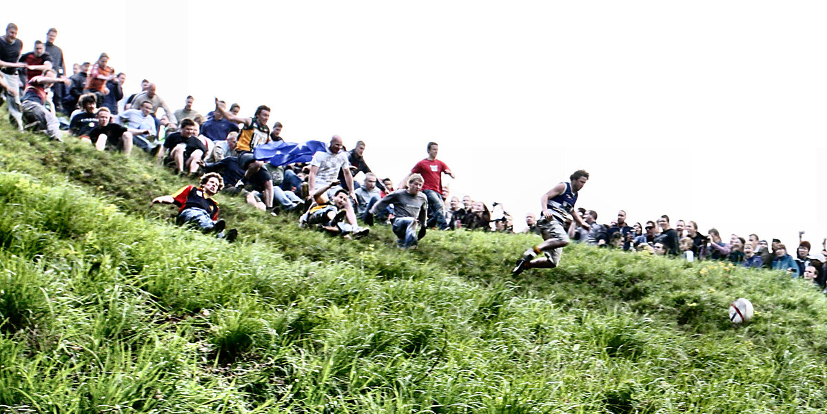 Вниз по холму. Куперсхилдская сырная гонка. Соревнование бег за сыром. Сырная гонка в Великобритании фото. Cheese Rolling Championship.