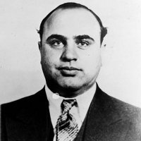 17 января 1899 года родился известный гангстер Аль Капоне, наводивший ужас на Чикаго в 20-30-е годы XX века. Под прикрытием легального бизнеса он занимался бутлегерством, игорным бизнесом и сутенерством, а уж сколько на его счету убийств – остается гадать. Мы вспомнили несколько фактов из его биографии 
Как попал в мафию.

Спустя время по приезде в Чикаго Аль Капоне начал работать вышибалой в заведении своего дяди Торрио, крупнейшего мафиози. Молодой Альфонс настолько втерся в доверие к родственнику, что вскоре стал правой рукой Торрио. Но потом два покушения на жизнь и тяжелое ранение Торрио в перестрелке заставили его отойти от дел. 26-летний Аль Капоне взял бизнес в свои руки. На тот момент банда насчитывала тысячу бойцов и собирала в неделю по 300 тысяч долларов дохода от проституции и подпольной продажи спиртного.

- Это девственная территория для публичных домов, - говорил Капоне о пригородах Чикаго.

Личная жизнь.

Гангстерская «империя» Капоне приносила ему 60 миллионов долларов в год. У него было множество домов во Флориде и Чикаго, которые охраняли круглые сутки, а вооруженные телохранители сопровождали босса повсюду. Капоне имел свой секретный вход в чикагские отели. Например, в «Метрополе» 50 комнат бронировались для его свиты, затем он приобрел роскошный «Лексингтон». Капоне был с юности женат на ирландке Мэй (интересно, что с ирландской мафией он жестоко расправлялся). Женщина, конечно, находилась в почетной ссылке, не мешая мужу брать всевозможные удовольствия от жизни. Капоне содержал много любовниц и отбирал все новых девиц из своих борделей. Знаменитый мафиози в молодости заболел сифилисом. Этой болезнью он «наградил» своего сына при рождении.

Знаменитый Кадиллак.

Став лидером ОПГ в Чикаго, Аль Капоне заказал персональный Кадиллак весом 3,5 тонны, чтобы обезопасить себя. Машина имела мощную броню, пуленепробиваемые стекла и съемное заднее стекло для стрельбы по преследователям. Интересно, что в 1933 году президент США Франклин Рузвельт был с визитом в Чикаго. Там его машину обстреляли — сам президент не пострадал, но ехавший с ним мэр города был смертельно ранен. После этого случая служба безопасности выбрала более надежную машину для президента. Почетную службу стал нести конфискованный двумя годами ранее у Аль Капоне бронированный Кадиллак. Кроме брони по всему корпусу и пуленепробиваемых стекол, эта машина была оборудована скрытыми бойницами в дверях, а через откидывающееся заднее стекло можно было вести огонь даже из пулемета.

Бойня в День святого Валентина.

В январе 1929 года люди из банды Багса Морана украли грузовики Аль Капоне и взорвали несколько принадлежавших ему баров. При этом главный боевик гангстера - Джек Макгорн по прозвищу Пулемет - попал в засаду и с трудом ушел живым. Аль Капоне решил отомстить и показать, кто в Чикаго хозяин. 14 февраля один из людей Капоне позвонил Морану и сообщил, что угнал грузовик с контрабандным спиртным. Моран велел пригнать грузовик в гараж, служивший тайным складом спиртного. Когда гангстеры Морана собрались для приемки груза, к гаражу подъехала машина. Из нее вышли четверо, двое из которых были в полицейской форме. Людей Морана поставили лицом к стене и расстреляли из автоматов. Шесть гангстеров умерли на месте, а еще один скончался от ранений в больнице. А вот главный соперник Капоне Моран на встречу опоздал и потому уцелел. Однако доказать убийства так и не смогли. У самого Капоне нашлось «железное» алиби на тот день.

Визитная карточка.

Аль Капоне промышлял контрабандой, сутенерством и игорным бизнесом, однако на визитной карточке гангстера значилась весьма законная профессия – «торговец мебелью». Конечно, все знали о его незаконной деятельности, но спецслужбы не смогли раздобыть доказательства этому и смогли арестовать Аль Капоне только по обвинению в уклонении от выплаты налогов.

Рэкет.

Именно Аль Капоне ввел такое понятие как «рэкет». Вскоре после того, как Капоне принял дело из рук своего дяди, он вошел в число пяти «владельцев» города. Они поделили Чикаго на сферы влияния и начали распоряжаться всем - от выборов мэра до продажи жевательной резинки.Вз 