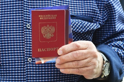    Мужчина держит в руках российский паспорт © РИА Новости