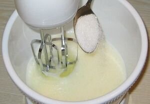     Чтобы наш тортик действительно получился вкусный, необходимо сделать бисквитный корж. Можно, конечно, себя не мучить и купить уже готовые коржи. Но поверьте, это не стоит того. Поэтому, не ленимся и берем в руки четыре яйца и миксер. В первую очередь в глубокую миску разбиваем яйца и в процессе отделяем белки от желтков. Для того, чтобы приготовить вкусный воздушный бисквит, лучше использовать миксер. Но, если под рукой не оказалось такого прибора, пробуем взбивать яйца ручным венчиком. Для этого дополнительно нужно много сил и терпения, так как чем лучше мы вспеним белковую массу, тем пышнее будет корж. Итак, медленно взбиваем наш главный ингредиент и постепенно по одной ложке добавляем к нему сахар и ванилин. Важно не переборщить с ванилином, иначе корж будет горчить. Сахара всего необходимо 200 грамм. Ну, а там уже на ваше усмотрение, если вы сладкоежка.   