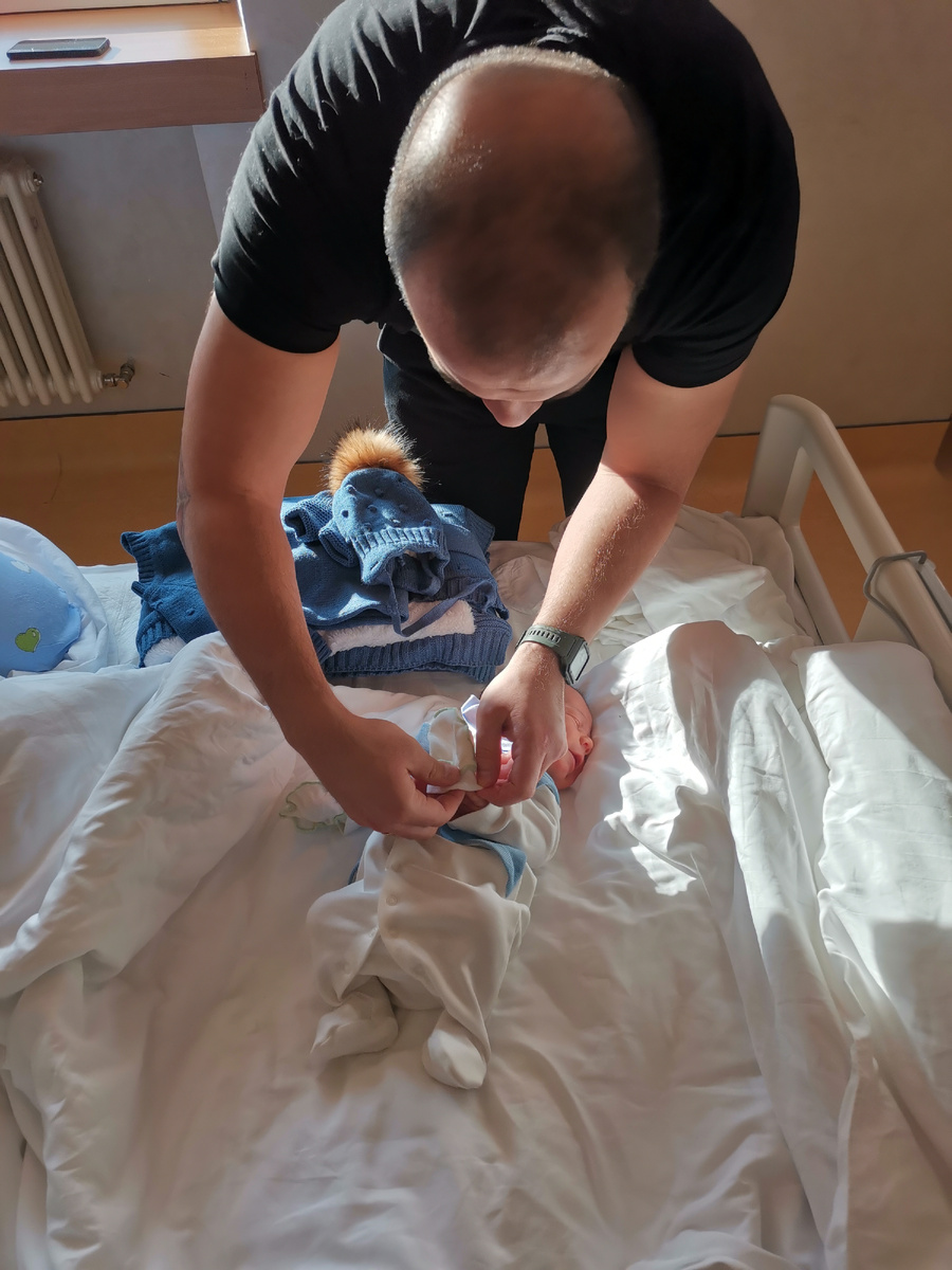 Муж одевает малыша. 