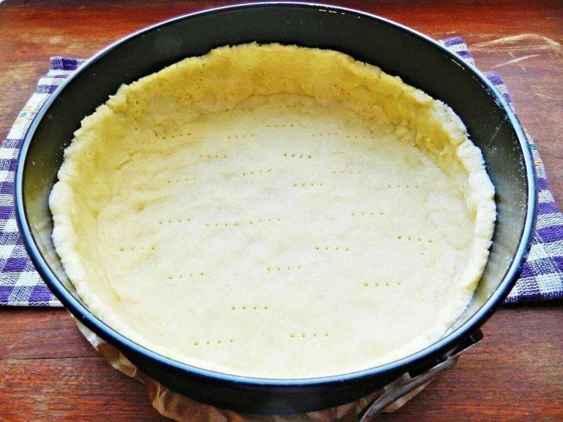 Раскатываем меньшую часть теста в виде круга по  диаметру формы, укладываем его на начинку и соединяем края бортиков и  верха пирога. Делаем сверху надрез для выхода пара. По желанию можно  смазать пирог желтком. 