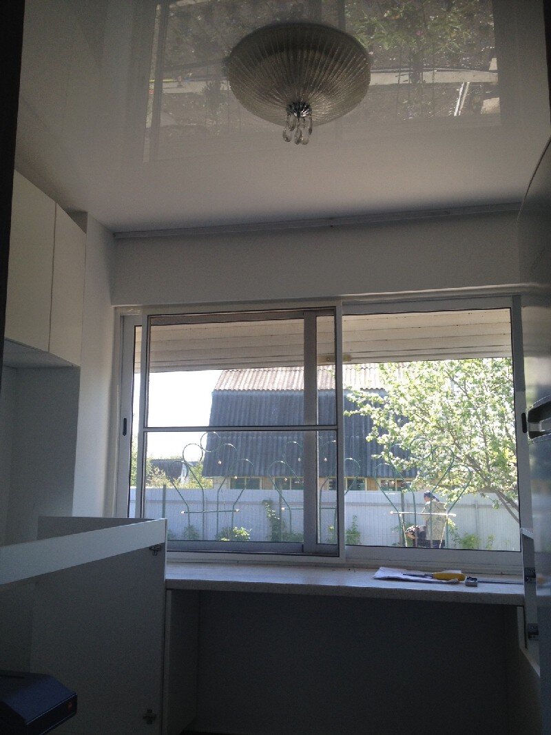 Лаковый белый виниловый натяжной потолок в дачном домике.