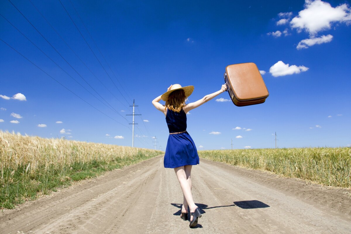 Девушка с чемоданом на дороге