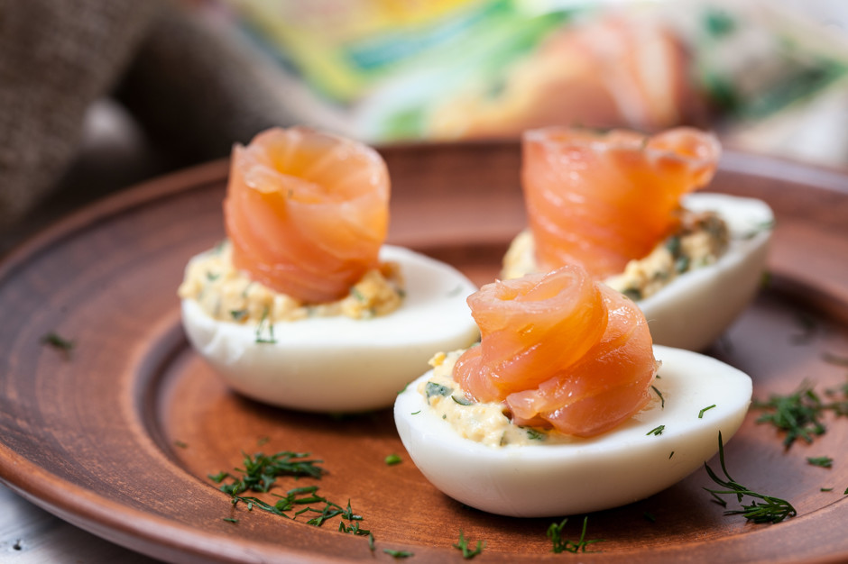 Яйца с рыбой – это прекрасная закуска, которая готовится «левой ногой», стоит недорого, а поставить ее можно даже на праздничный стол. По своей сути, это яйца, фаршированные рыбой, но благодаря правильным ингредиентам и их пропорциям, получается вкуснятина, которая будет улетучиваться со стола подобно эфиру.