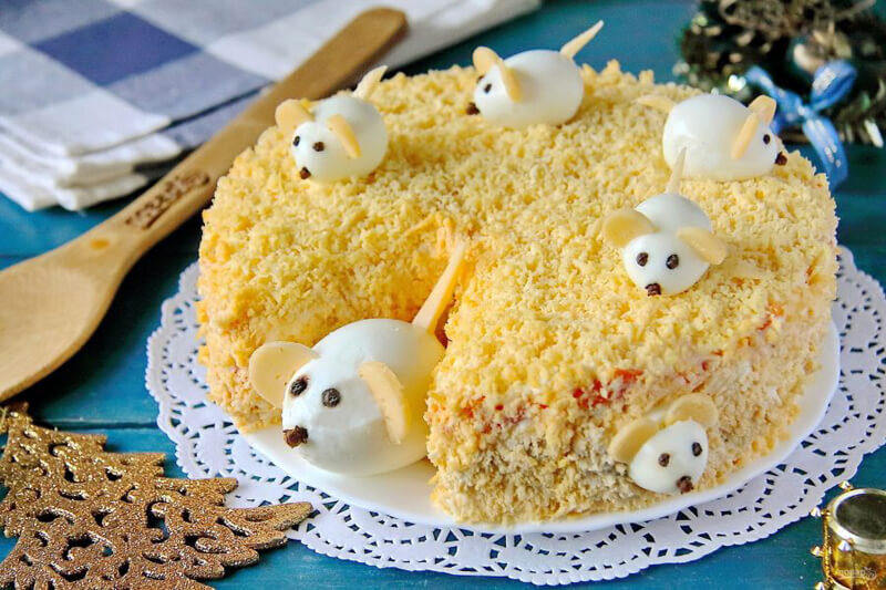 Салат с ветчиной и перепелиными яйцами, оформленный мышками. По этой причине его можно назвать «Мышки в сыре»: мышки атаковали наш сырный салат и очень хотят полакомиться им вместе с нами.