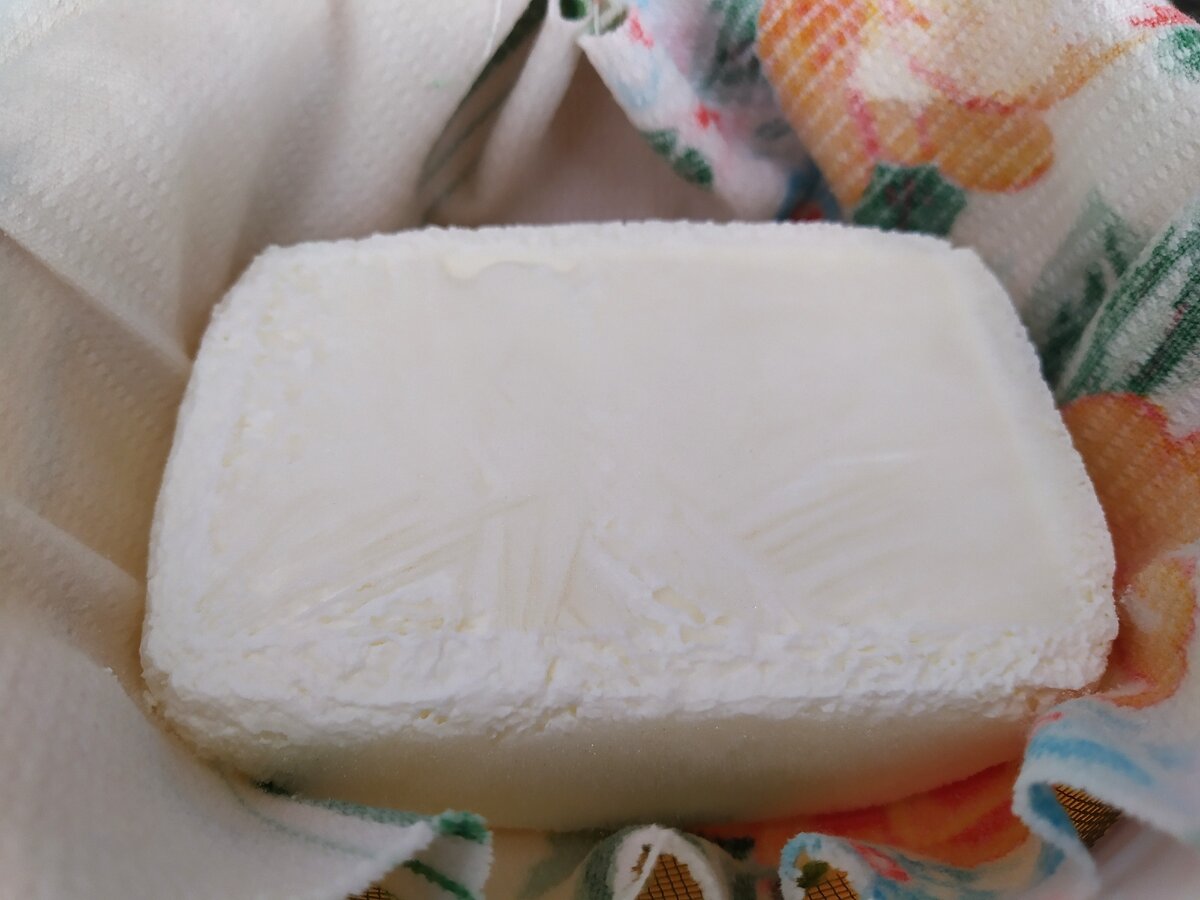 Замерзший кефир выкладывается в застеленное тканью сито.