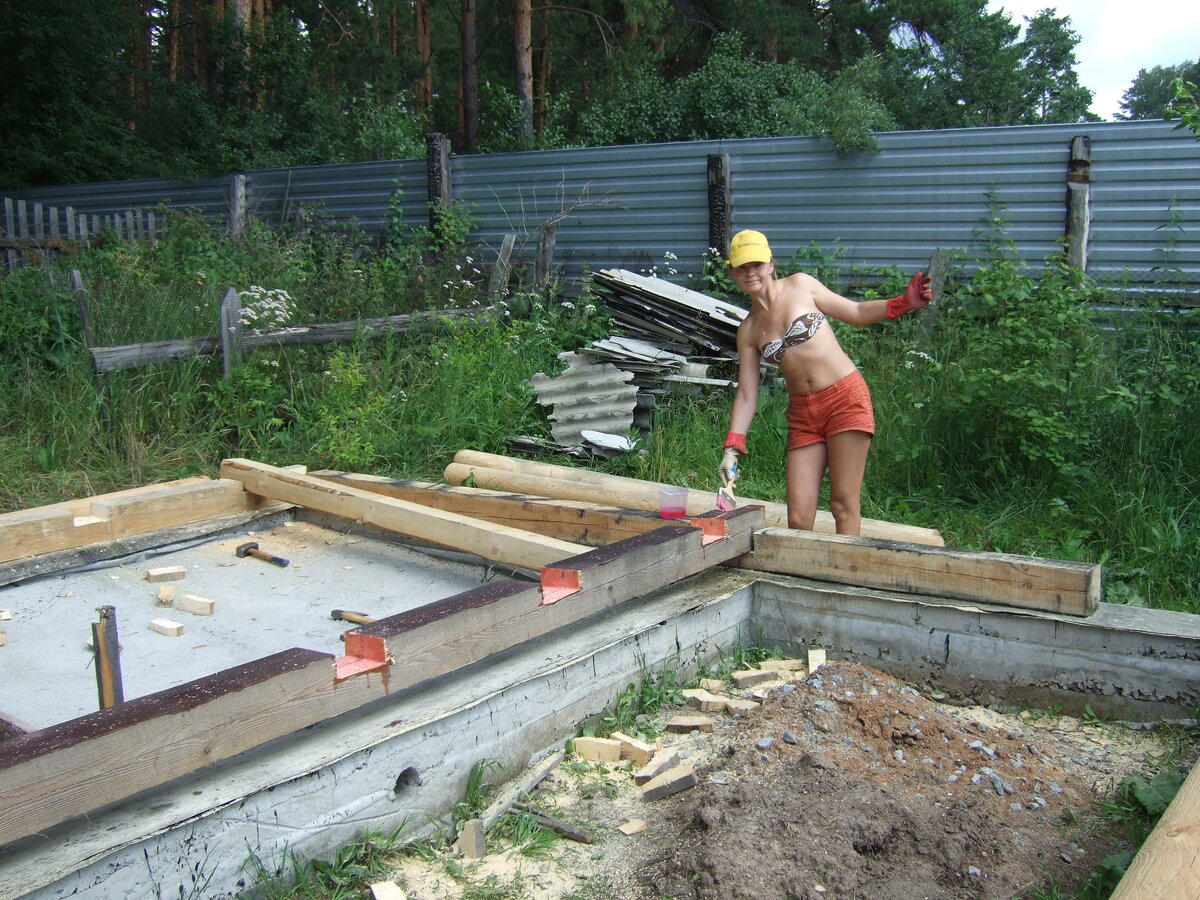 Зая обрабатывает брёвна антисептиком.