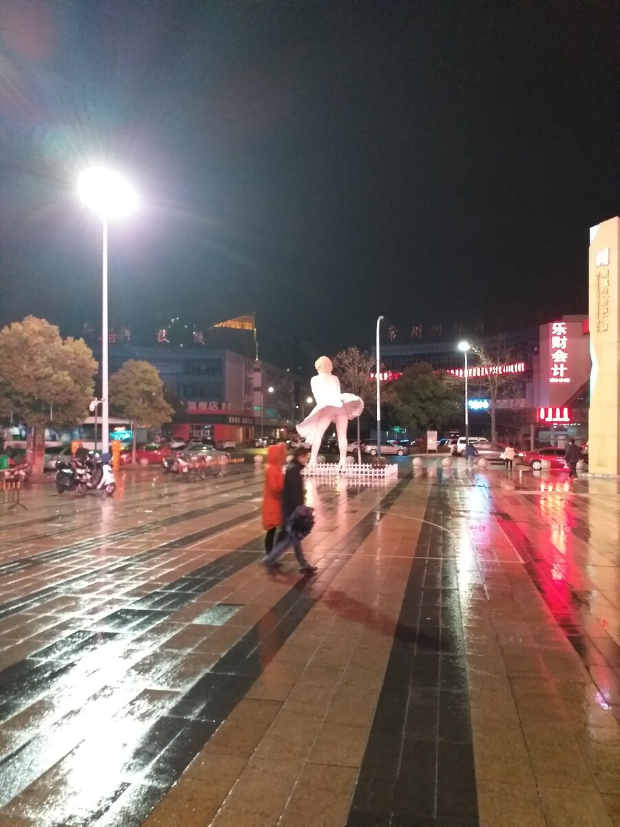 Мерлин монро стоит на площади перед настоящим японским рестораном