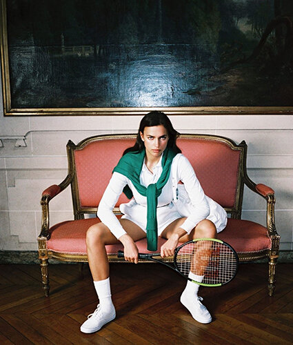 Ирина Шейк показала, как супермодели проводят время дома. 34-летняя икона стиля блеснула в новой съемке для журнала Interview, показав сразу несколько дерзких образов в лучших традициях спортшика и моды 90-х. 
К лицу Ирины Шейк оказался и образ теннисистки, построенный вокруг кипенно-белого цвета. Мини-шорты и поло с длинным рукавом зарифмованы с изумрудным пуловером, свободно накинутым на плечи. Ракетку супермодель держит в руках вполне уверенно!
