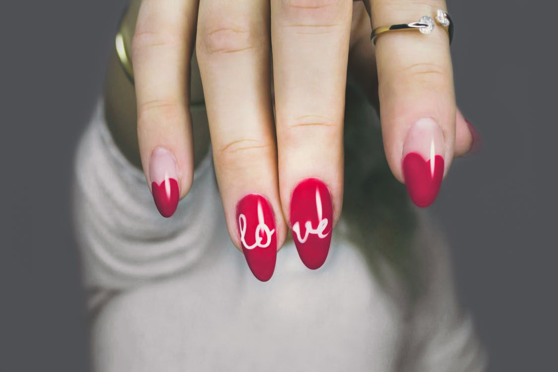 https://www.pexels.com/photo/red-and-white-manicure-with-love-print-887352/